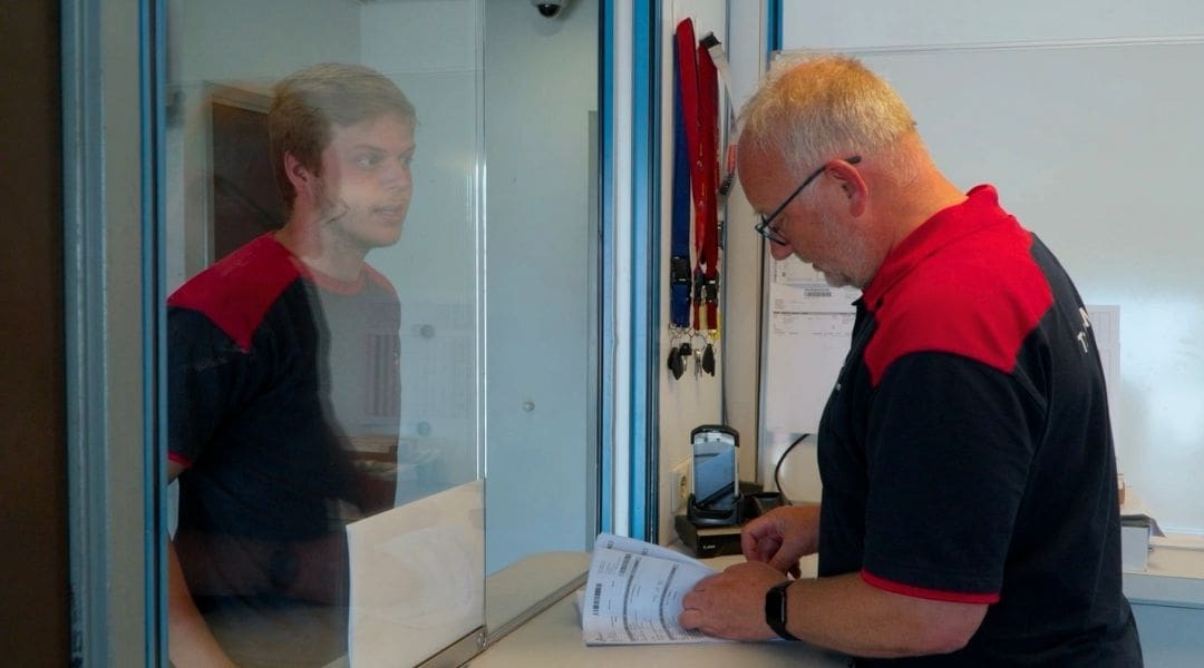 Medewerker leunt voor een Sluyter Logistics-vrachtwagen op het terrein van de vestiging in Deventer.