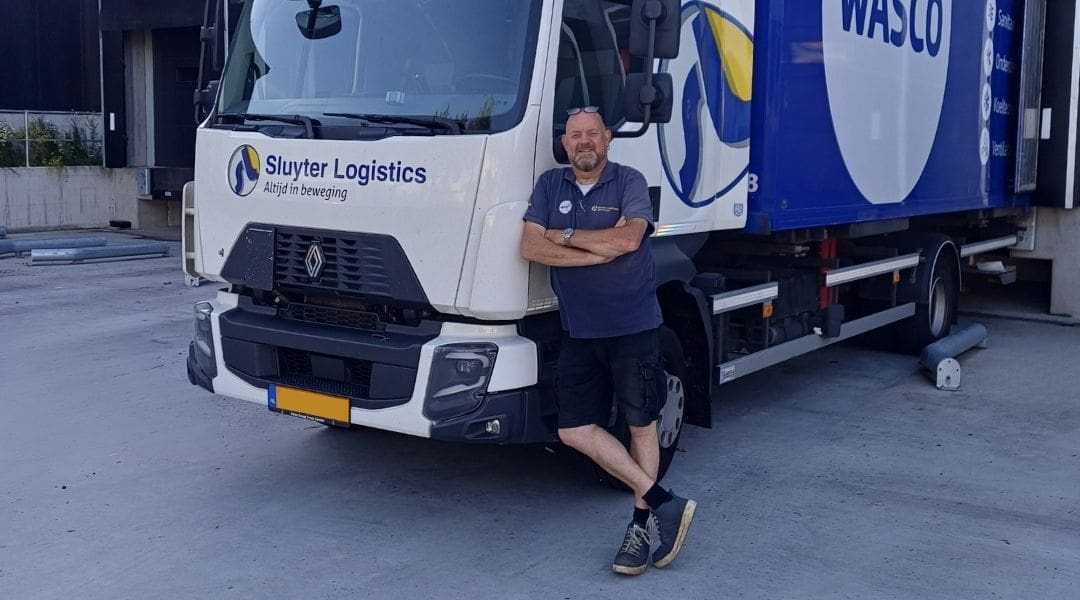 Chauffeur kijkt vanuit de cabine van een Sluyter-vrachtwagen op de vestiging in Tilburg.